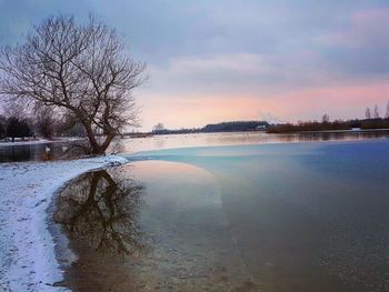 Scenic view of lake against sky at sunset