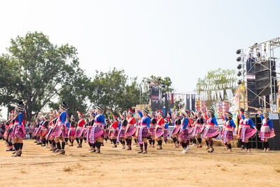 Group of people on stage against clear sky