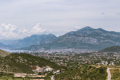 Aerial view of townscape and mountains against sky