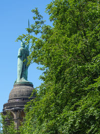 Low angle view of statue against trees