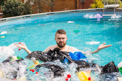 Portrait of smiling man swimming in pool