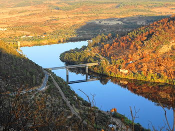 Scenic view of river amidst trees against sky during autumn