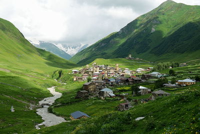 Scenic view of village by houses against sky