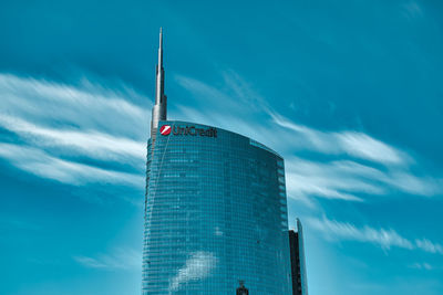 Low angle view of modern building against cloudy sky