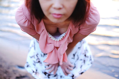 Midsection of woman with pink hair sitting outdoors