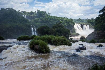 Scenic view of waterfall against sky