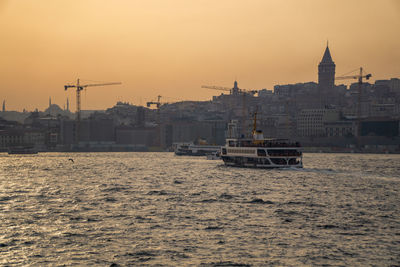 Boats in sea against buildings in city