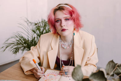 Young woman with book sitting at desk