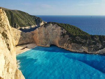 Rock formation against sea in sunny day