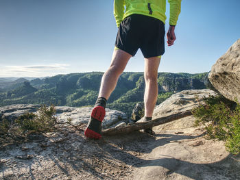 Rear view of man on rock against sky