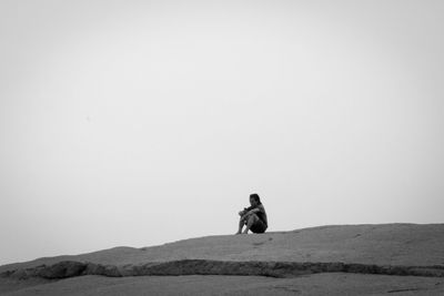 Man on mountain road against clear sky