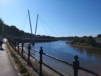 Bridge over river against clear blue sky