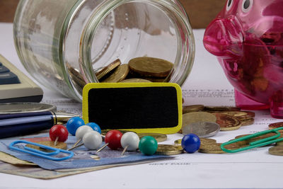 Close-up of coins with office supply on table