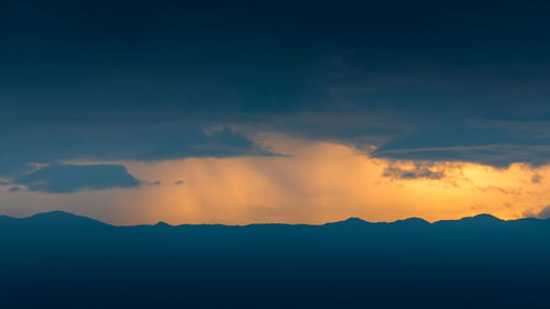 Low angle view of silhouette mountain against dramatic sky