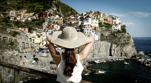Rear view of woman standing against buildings at vernazza