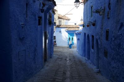 People walking on alley amidst residential buildings