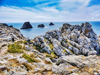 Rocks on sea shore against sky