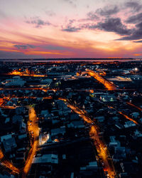 High angle view of illuminated buildings in city during sunset