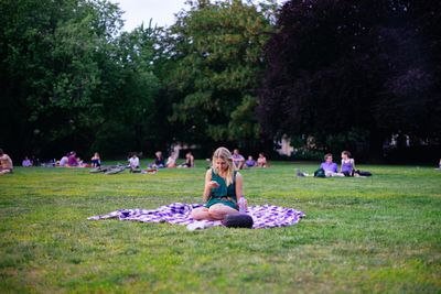 People relaxing on grassy field in park