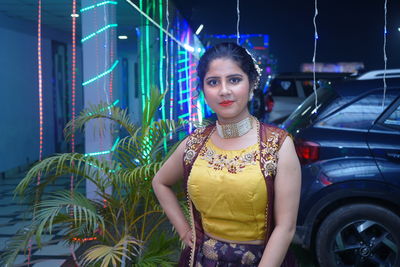 Portrait of smiling young woman standing at night