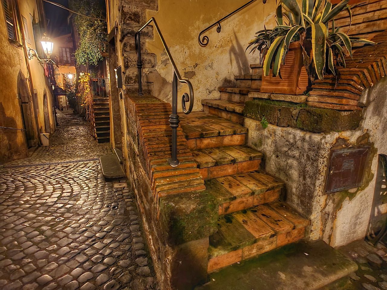 architecture, alley, ancient history, built structure, staircase, building, street, no people, city, building exterior, urban area, illuminated, cobblestone, history, night, footpath, wall, outdoors, wood, screenshot, the past, old, travel destinations