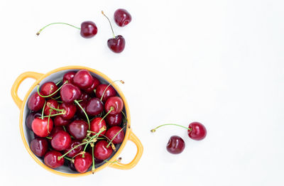 High angle view of cherries in bowl against white background