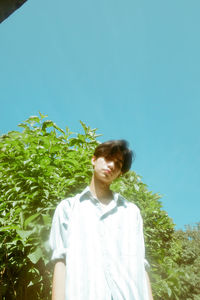 Young man standing against sky