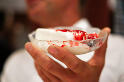 Close-up of hand holding ice cream in plate