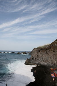 Rock formation on beach against sky