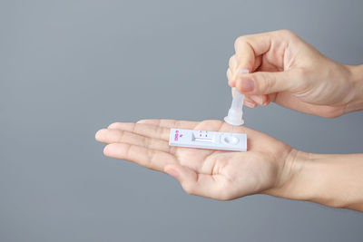 Close-up of hand holding text against white background