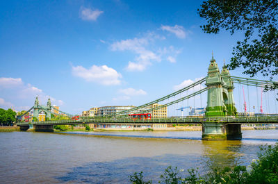 Bridge over river against cloudy sky