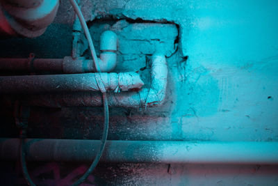 Close-up of rusty pipe against blue wall