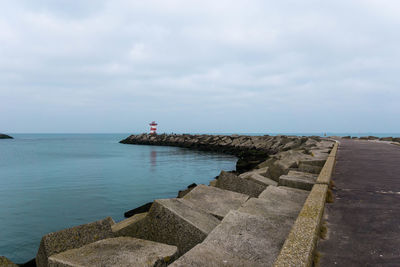 View of jetty in sea against cloudy sky