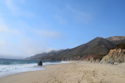 Scenic view of beach against blue sky