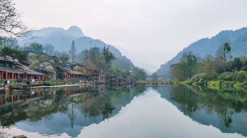 Scenic view of lake by buildings against sky