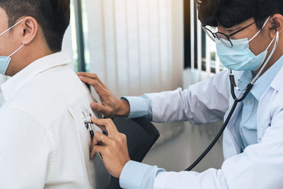 Midsection of doctor examining patient in hospital