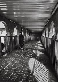 Rear view of people walking on bridge