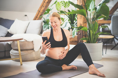 Full length of young woman exercising at home