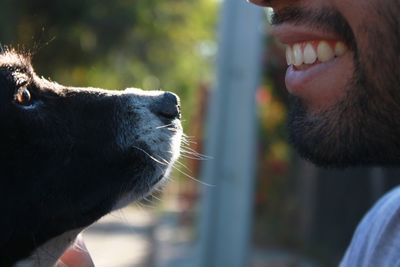 Midsection of smiling man by dog at outdoors