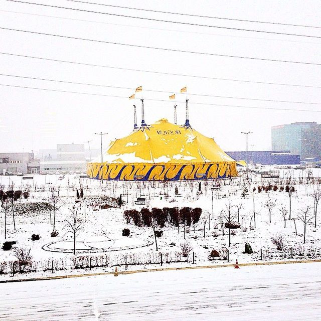 snow, winter, cold temperature, season, building exterior, architecture, built structure, weather, covering, yellow, clear sky, frozen, outdoors, transportation, day, white color, power line, nature, street, sky