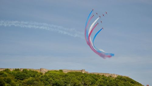 Low angle view of airshow against sky