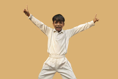 Full length of boy standing against gray background