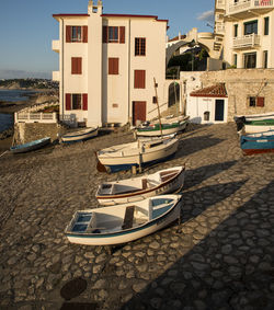 Boats moored on street by buildings in city