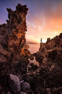 Rock formations on land against sky during sunset