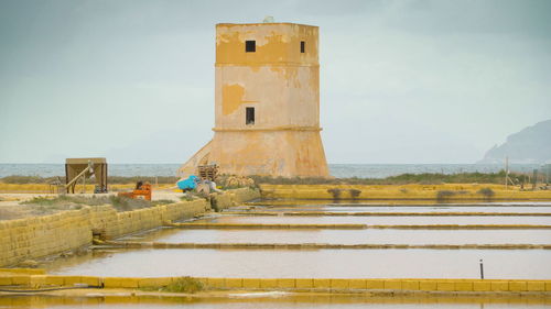 Built structure on beach against sky