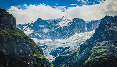 Scenic view of mountains against cloudy sky during winter