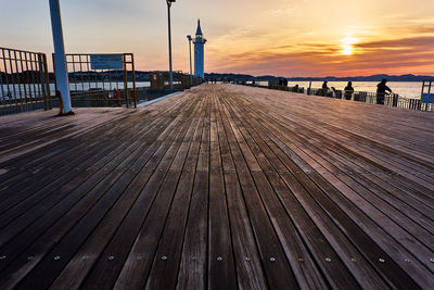 Pier on sea against sky during sunrise