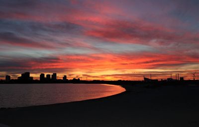 Sunset view from copenhagen city beach withbuildings in shilouette.