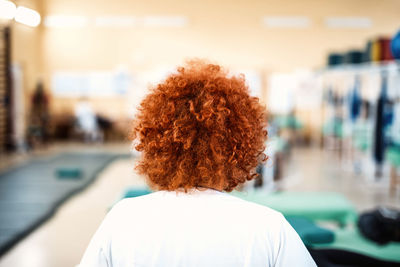 Rear view of redhead woman with curly hair