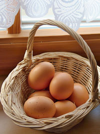 Close-up of fresh eggs in wicker basket on table